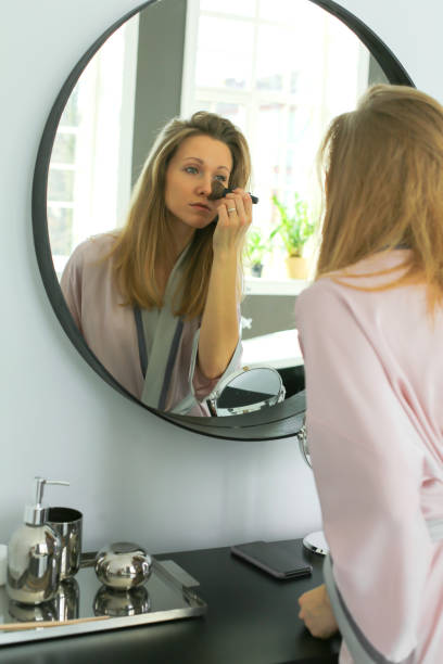 istock pretty woman is applying makeup 1144386309