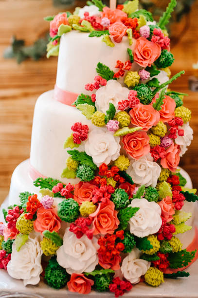 istock Beautiful white rustic wedding cake with flowers on table. 1144389240