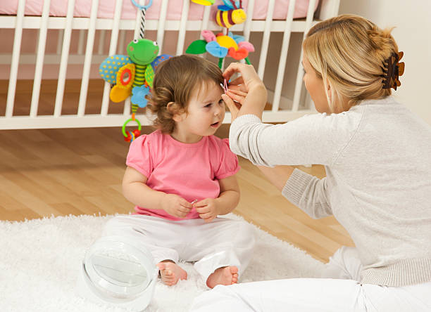 Mother Styling Baby Girl Hair stock photo