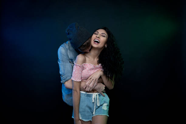 istock Young attractive couple standing in front of black background 1144390088