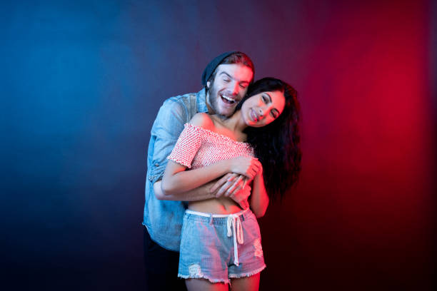 istock Young attractive couple standing in front of black background 1144390769