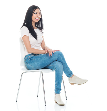 Hermosa joven Latina vestida con una camiseta y jeans-sentado photo