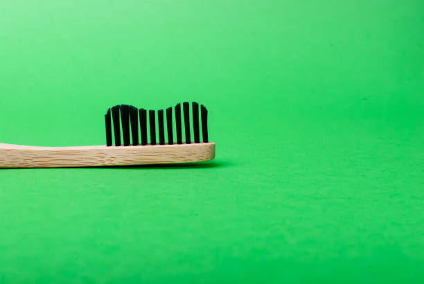 widok z boku głowy bambusowej szczoteczki do zębów na zielonym tle - toothbrush dental hygiene dental equipment rainbow zdjęcia i obrazy z banku zdjęć