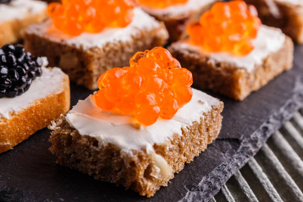 istock Snack with red and black caviar on a stone plate 1144394122