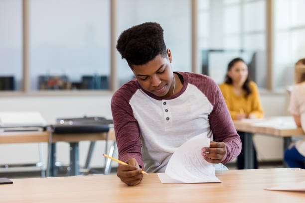 istock Young adult takes Biology final while friends chat 1144395159