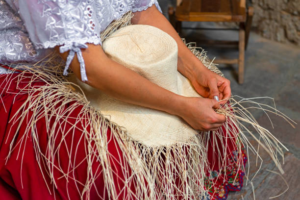 Panama Hat Weaving in Cuenca, Ecuador A woman weaving a Panama hat, also known as the traditional brimmed straw hat made of the Toquilla palm, is on the Unesco Intangible Cultural list and famous from the city of Cuenca, Ecuador. palm fiber stock pictures, royalty-free photos & images