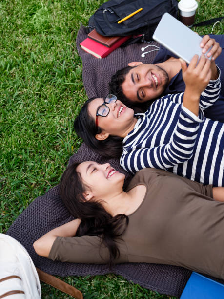 istock Young people lying on back and taking selfie with tablet 1144399564