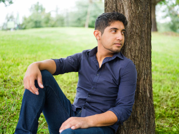 istock Happy young man sitting outdoors and smiling 1144399630