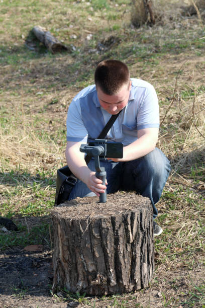 istock A young man videotaping on a smartphone. Uses gimbal to get smooth shots. Controls the recording by touching the screen. 1144405192