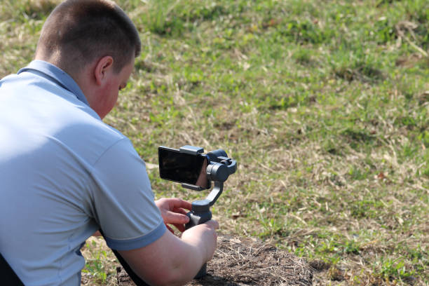 istock A young man videotaping on a smartphone. Uses gimbal to get smooth footage. Closely watching the movie shooting. 1144405199