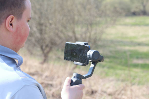 istock A young man videotaping on a smartphone. Uses gimbal to get smooth footage. Closely watching the movie shooting. 1144405200