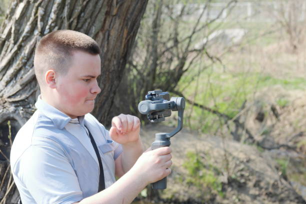 istock A young man videotaping on a smartphone. Uses gimbal to get smooth footage. Closely watching the movie shooting. 1144405257