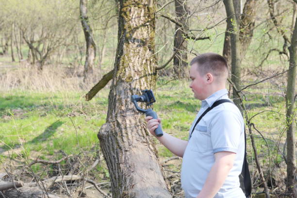 istock A young man videotaping on a smartphone. Uses gimbal to get smooth footage. Closely watching the movie shooting. 1144405274