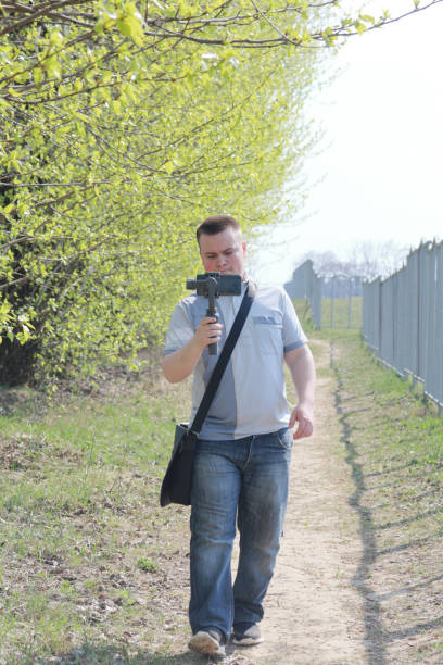 istock A young man videotaping on a smartphone. Uses gimbal to get smooth footage. Closely watching the movie shooting. 1144405307