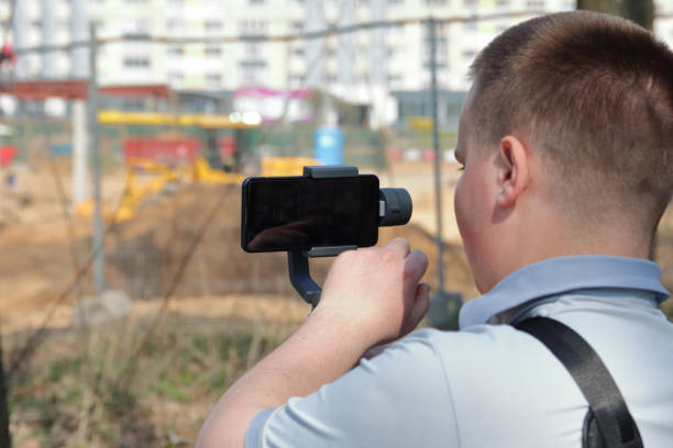 istock A young man videotaping on a smartphone. Uses gimbal to get smooth footage. Closely watching the movie shooting. 1144405319