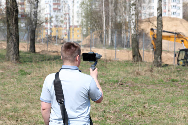 istock A young man videotaping on a smartphone. Uses gimbal to get smooth footage. Closely watching the movie shooting. 1144405321