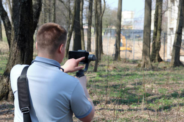 istock A young man videotaping on a smartphone. Uses gimbal to get smooth shots. Controls the recording by touching the screen. 1144405325