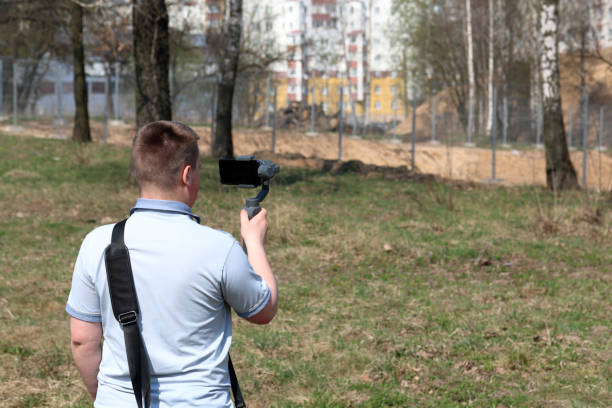 istock A young man videotaping on a smartphone. Uses gimbal to get smooth footage. Closely watching the movie shooting. 1144405326