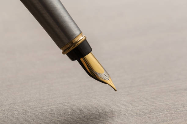 istock fountain pen on wooden table 1144409737