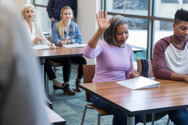 istock Woman raises her hand to ask question during meeting 1144410706