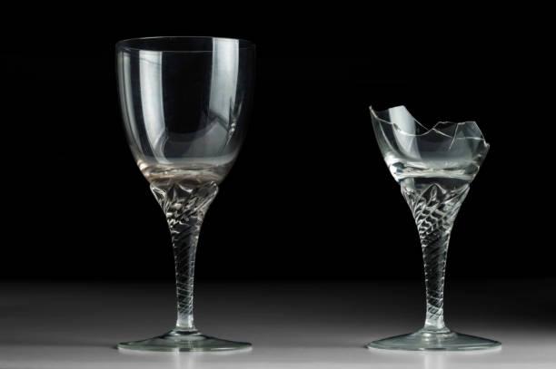 istock Two crystal wine glass on a black mirror background. New and broken 1144410798