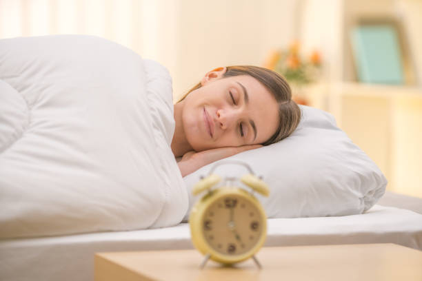 istock The sleeping woman on the background of a clock 1144411146