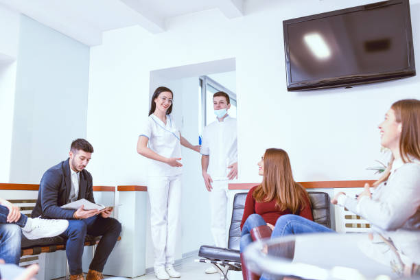istock Dental Assistant And Surgeon Inviting Patients 1144413057