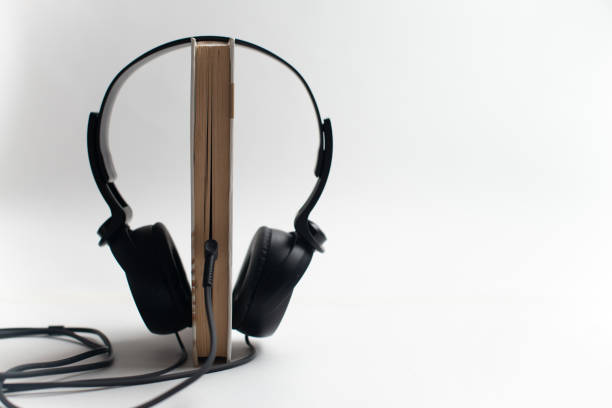 słuchawki i książki audiobook concept, słuchawki z książkami - single word text text messaging paper zdjęcia i obrazy z banku zdjęć