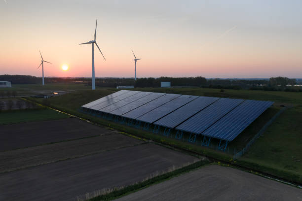 Wind turbines and solar panels at sunset Wind turbines and solar panels generating green energy during sunset as seen from above in Waalwijk, Noord Brabant, Netherlands berkel stock pictures, royalty-free photos & images