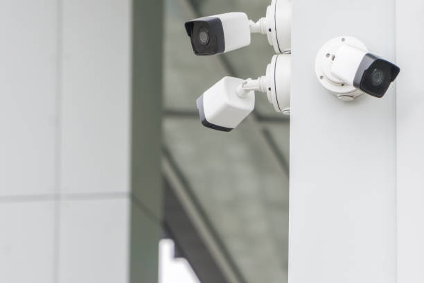 Group of CCTV security cameras outside on modern building wall in city stock photo
