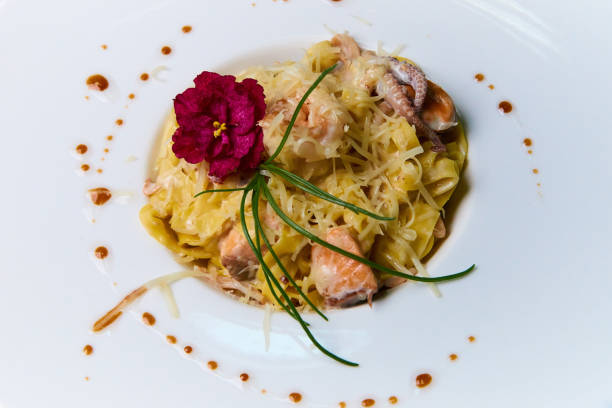 istock Seafood dish with sauce and flower on white background. 1144418373