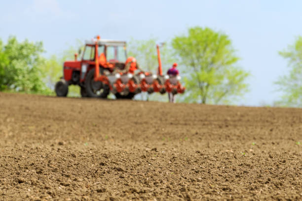 istock Farmer repairing tractor with seeder in field 1144419289