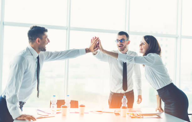 istock The three business people greeting at the table on the sunny background 1144419624