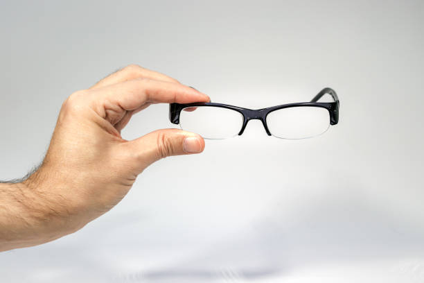 istock A male hand holding a half frame eyeglasses isolated over white. 1144420525