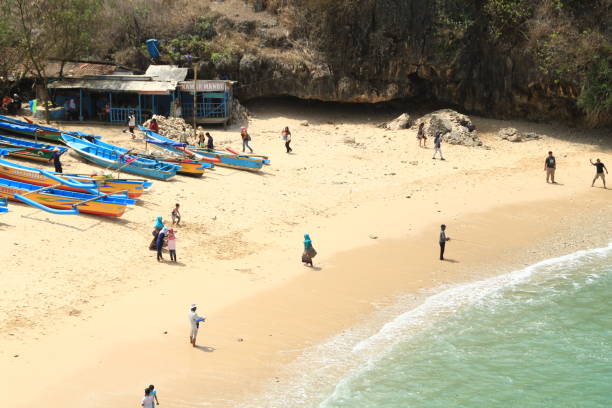 os turistas apreciam a praia da vista de gesing, gunung kidul, yogyakarta, indonésia - algi - fotografias e filmes do acervo