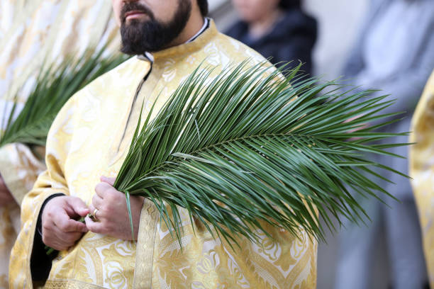Valencia, Spain - April 2, 2023: People with religious clothing walking in the street for the Semana Santa Marinera celebration in the coastal area of the city. This processions happen every year and gather a lot of locals and tourists eager to witness it.