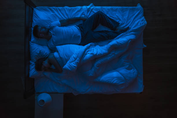 istock The man and woman sleeping on a bed. Evening night time. View from above 1144428611