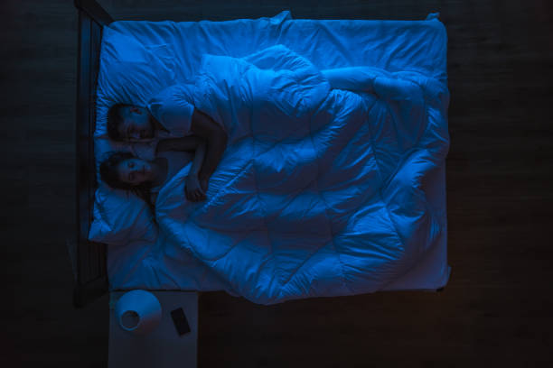 istock The couple sleeping on a bed. Evening night time. View from above 1144428614