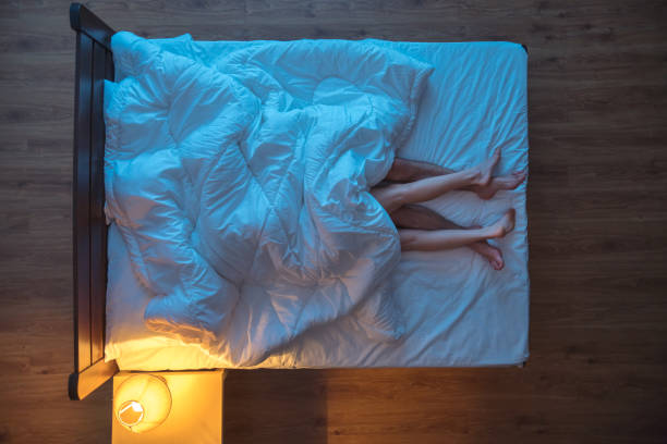 istock The couple lay under blanket on the bed. evening night time. view from above 1144428649