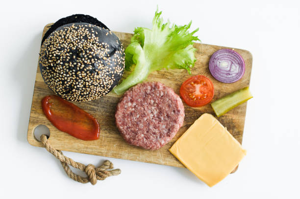 istock Ingredients for the black Burger on wooden cutting Board. 1144430423