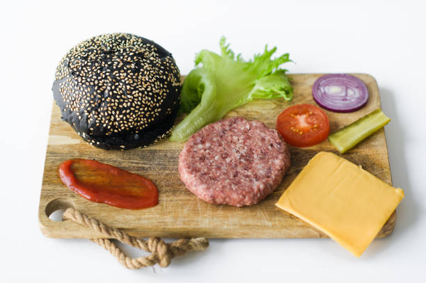 istock Ingredients for the black Burger on wooden cutting Board. 1144430428