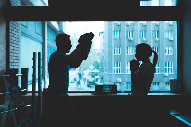 istock Young man and woman boxing together 1144430698