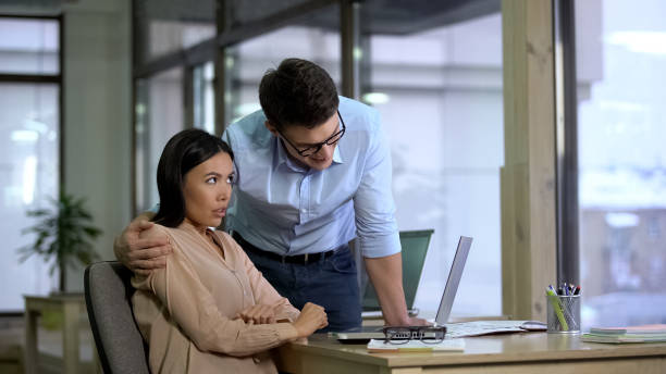 Young businessman hugging beautiful female secretary, sexual harassment, abuse Young businessman hugging beautiful female secretary, sexual harassment, abuse uncomfortable stock pictures, royalty-free photos & images