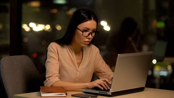 istock Concentrated copywriter typing article on laptop at night, deadline overwork 1144431627