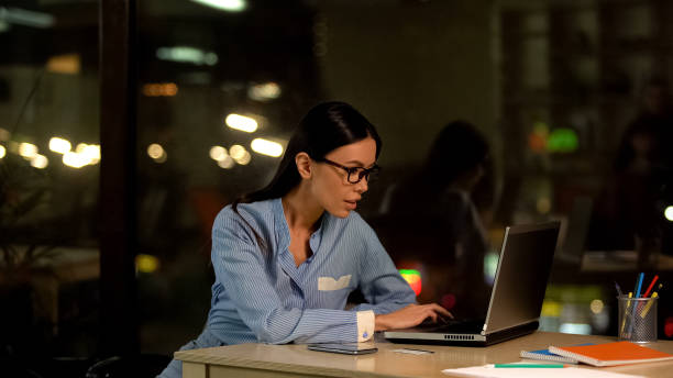 istock Attractive office worker typing on laptop at night, internet research, job 1144431633