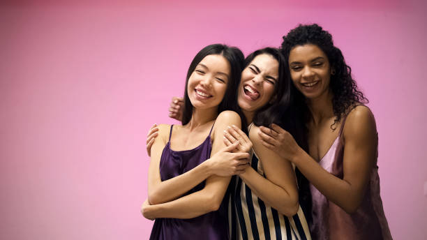 istock Cheerful multiracial friends posing for camera and having fun, pink background 1144431640
