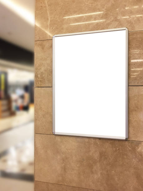 istock (Clipping path) Empty advertising or information board hanging on wall with defocused store background 1144431758
