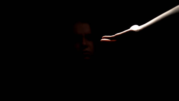 istock Helping hand giving support to depressed abandoned woman in darkness, aid 1144433232