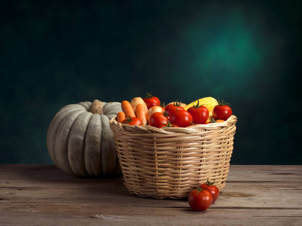 Pumpkin and Organic Vegetables in Wicker basket on green and wooden background.