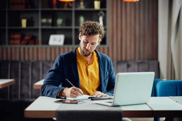 istock Man taking notres and sitting in restaurant. 1144433387